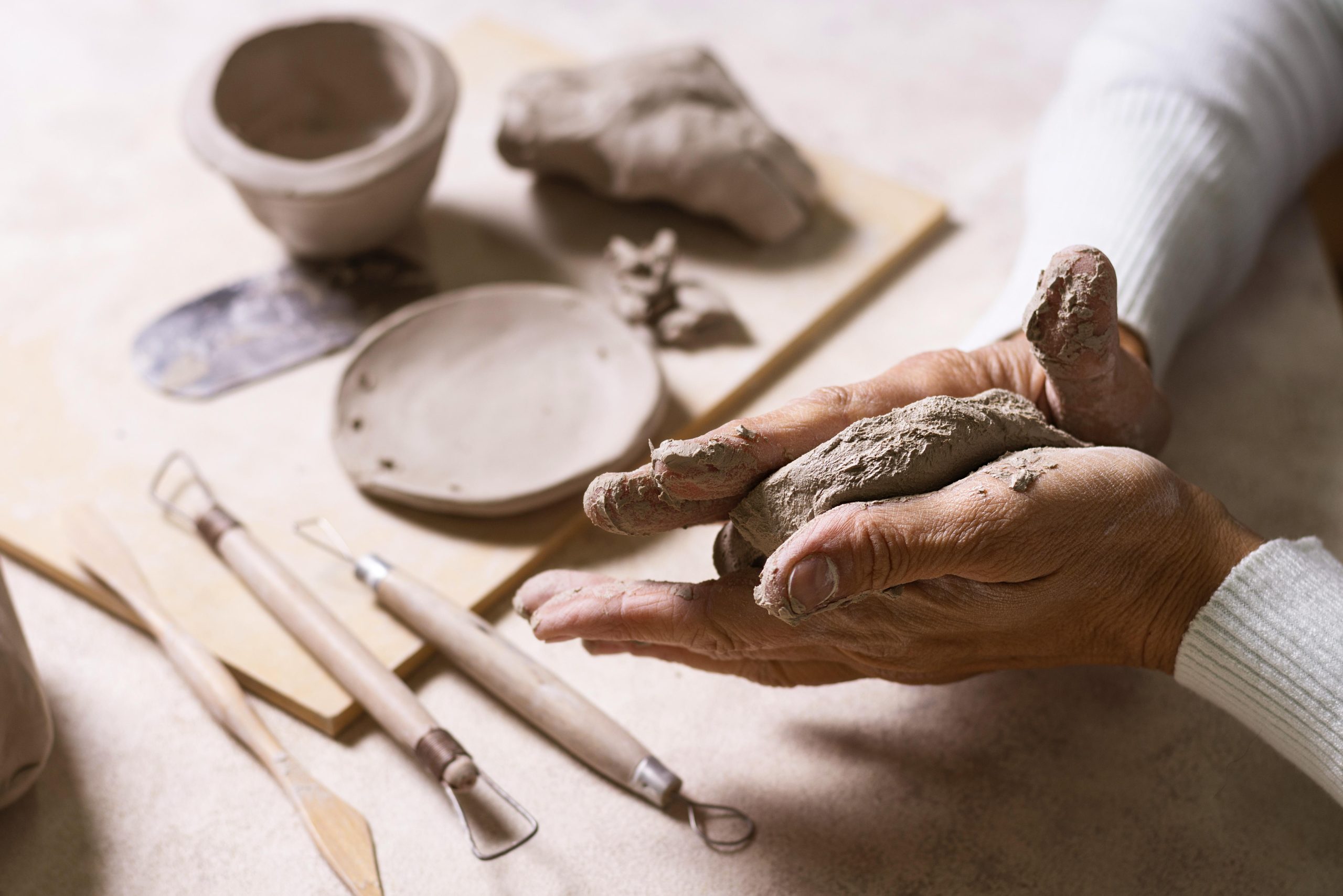 Person making a piece of clay work in the pottery studio